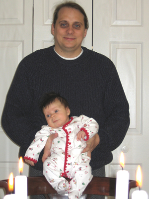 John holding Erika, Christmas candles in foreground