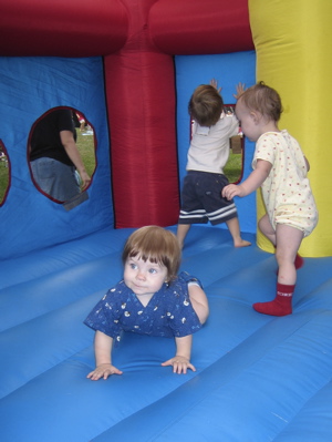 Erika crawling in a moon bounce with other kids
